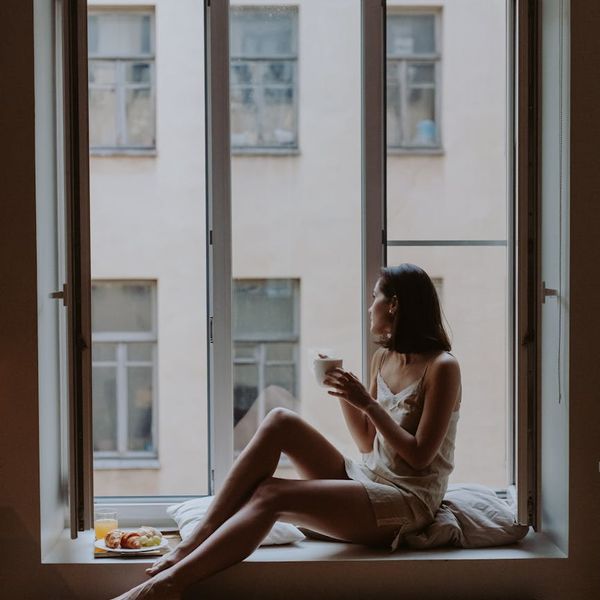 Person sitting peacefully after a workout, looking out a window.